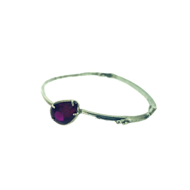 Full view of ruby shea bangle on white background.