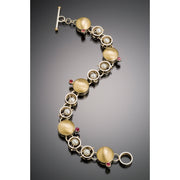 Bubble style link bracelet in sterling silver, 18k yellow gold, pearls and garnets.