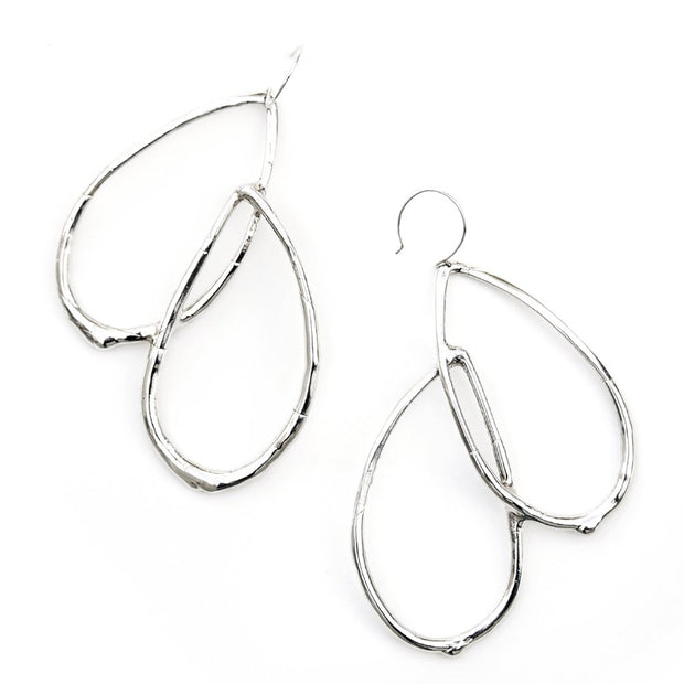 Dangle earrings featuring curved tear-drop shaped forms with an organic texture resembling a smooth twig or vine.