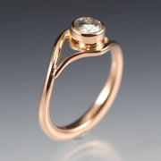 Side view of a Rose Gold and Moissanite Engagement Ring, the metal gently wraps around the stone, like a vine or wave.