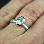 Bezel Set Oval Engagement Ring featuring a organic faceted band on a woman's hand.