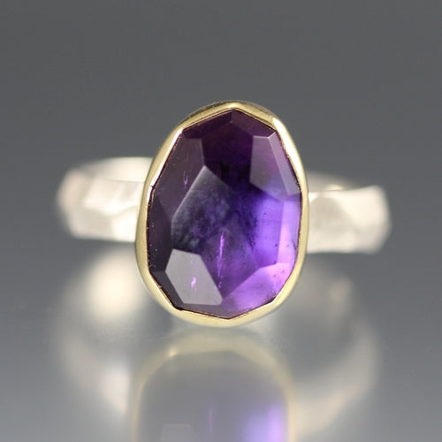 Full image of Rose Cut Amethyst Chiseled Ring. This ring has an ovular cut purple smethyst gem set in gold laying on a silver chiseled band.