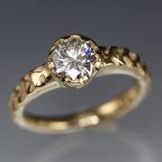 Full image of Moissanite Cobblestone Engagement Ring. This ring is in gold and its texture resembles that of a cobblestone. It has a set diamond on the top.