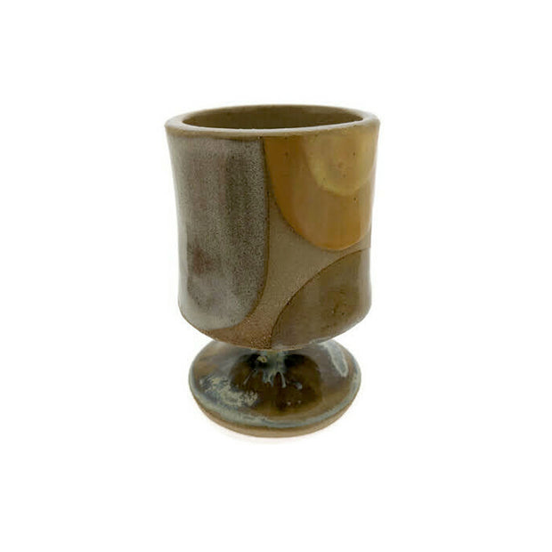 Full image of circular pedestal liquor sipper. Made with a variety of creams, whites and tans. This pedestal looks like a regualr kind of pedestal you see on glasses like champagne or wine glasses.