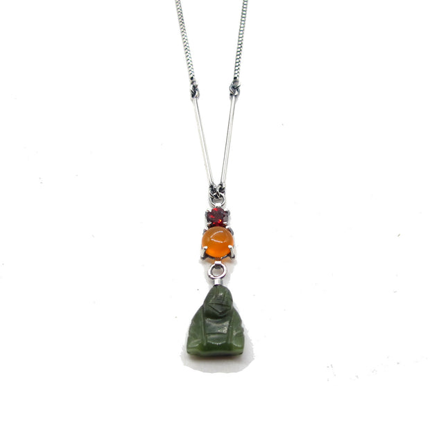 Detailed view of pendant on Buddha Y Necklace. The pendant has three set gems, garnet at the top, citrine in the middle and a jade organism at the bottom.