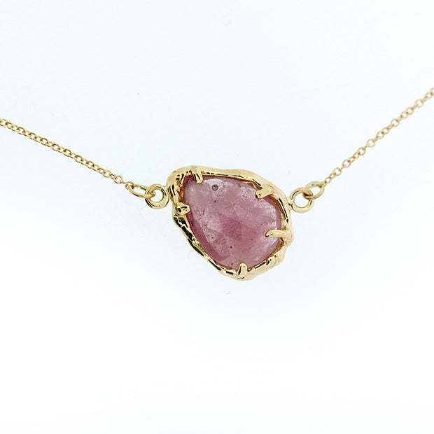 Close up of pendant on Marta necklace. A lovely imperfect rose cut Umba Sapphire perched at an angle along it's chain in a subtle peachy pink tone.  This gemstone is surrounded by organic, highly textured 14K Yellow Gold. On a dainty 16" solid 14K yellow gold chain.