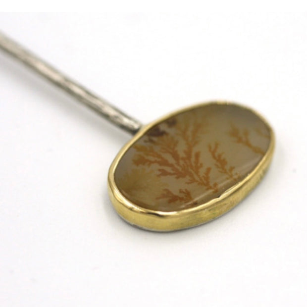 Close up image of detail of dendritic agate oval part of Leaves Hinged Dendritic Agate Oval Champagne Diamond Pendant. It is encased in 18 karat gold.