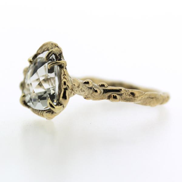 Side view of an organic inspired ring made in 14k yellow gold and trillion-shaped white topaz