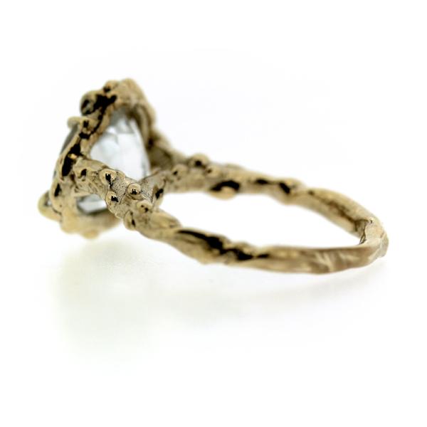 Back view of an organic inspired ring made in 14k yellow gold and trillion-shaped white topaz