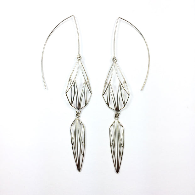 Full image of Large Double Dangling Openwork Earrings on white background. These earrings are dangle earrings that showcase a medium sized teardrop shape on the top and a smaller/skinnier diamond shape below it created with lines of wire. This piece has a very architectural feel to it.