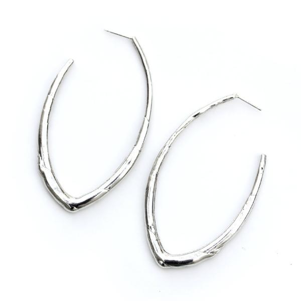 A sterling silver elongated hoop earring featuring an organic texture like a twig.