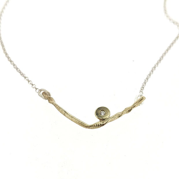 Close up view of pendant on Kate necklace. A sweet V-style necklace in yellow gold accented with one sparkling diamond.