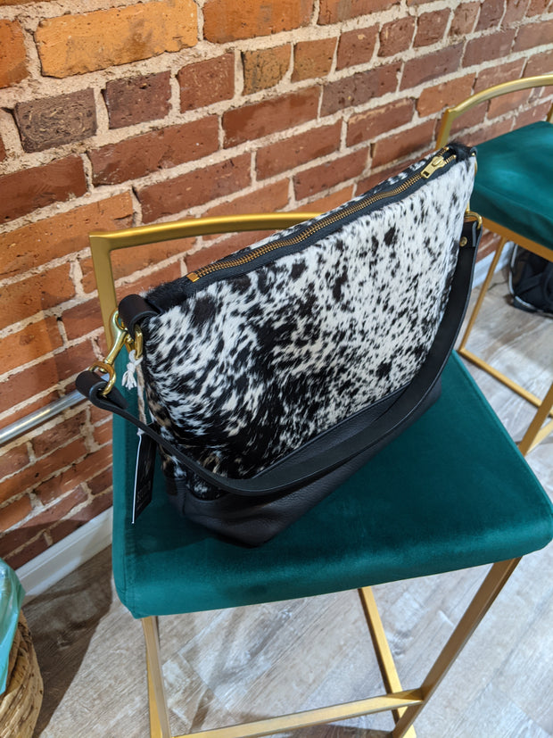 Full angled view of Virginia shoulder bag sitting on chair.