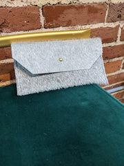 Close up image of grey phone clutch on chair.
