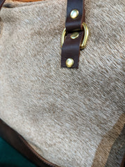 Close up image of buckle on Ashlyn Tote Bag. This buckle is made of a brown vegan leather and brass accents.