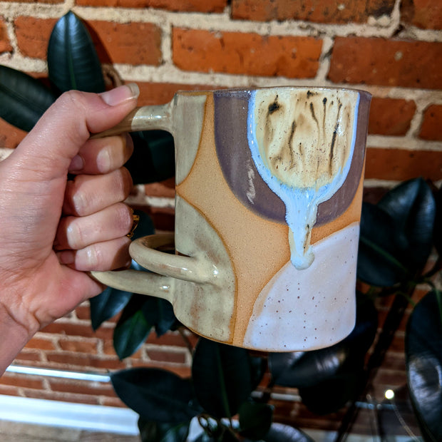 Full image of horizontal arch mug being held to give idea of scale of piece.