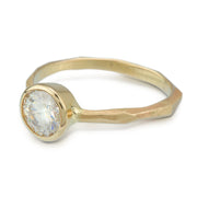 Full view of Thin faceted Engagement Ring in yellow gold. This engagement ring has a thin band with a chiseled texture and a set moissanite/diamond at the top.