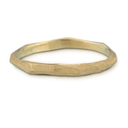 Full view of Skinny Facet Ring. This wedding band is in a yellow gold metal with a chiseled texture on top.