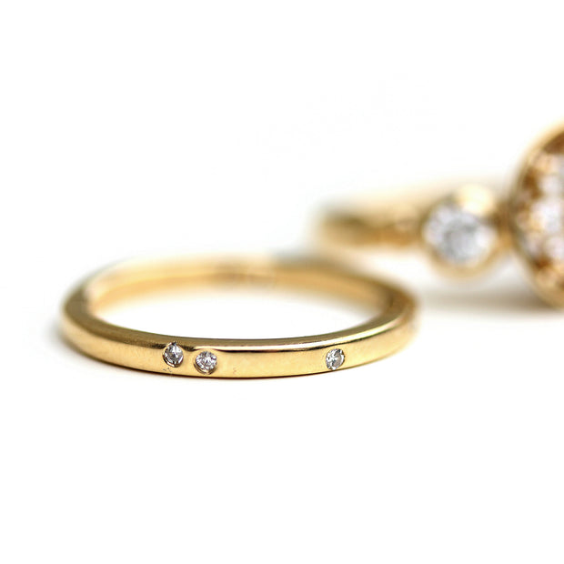 ethically made wedding band, flat style with scattered diamonds flush set or embedded into the surface.