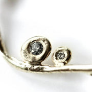 Detail photo of bezel set diamonds on a necklace.