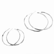 Full view of large and medium faceted hoop earrings next to one another.