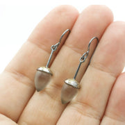 full view of Honed Quartz Drop Earrings being held to help give an idea of its scale.