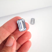 Full view of Emerald Cut Diamond Illustration - Stud Earring being held to help give an idea of its scale.