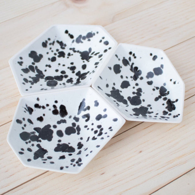 Full image of all three geometric ring dishes placed together. These dishes have what look like black ink spots on top of a white finish.