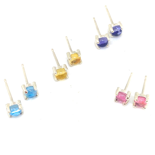 Full view of side profile of all four colored (light blue, yellow, navy blue, and pink) studs.