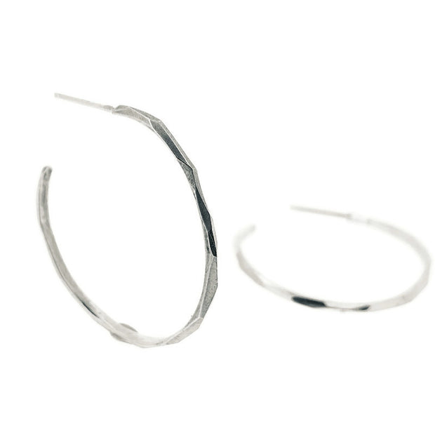 Full view of medium faceted Hoop Earrings. One is laying down and the other is propped up.