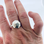 Full image of faceted large Dome Ring on finger to give idea of scale of piece. The pendant is in the shape of an octagon and lays on a silver band. 