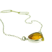 Angled view of gemstone on pebble - citrine rose cut necklace.