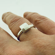Full view of faceted small square ring on finger to give idea of scale of piece.
