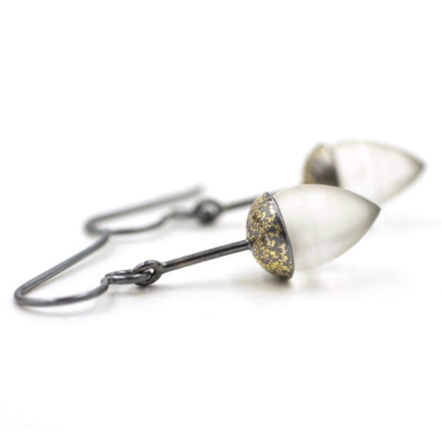 Full view of Honed Quartz Drop Earrings. these earrings showcase a cone shaped quarts set in oxidized silver with gold accents.