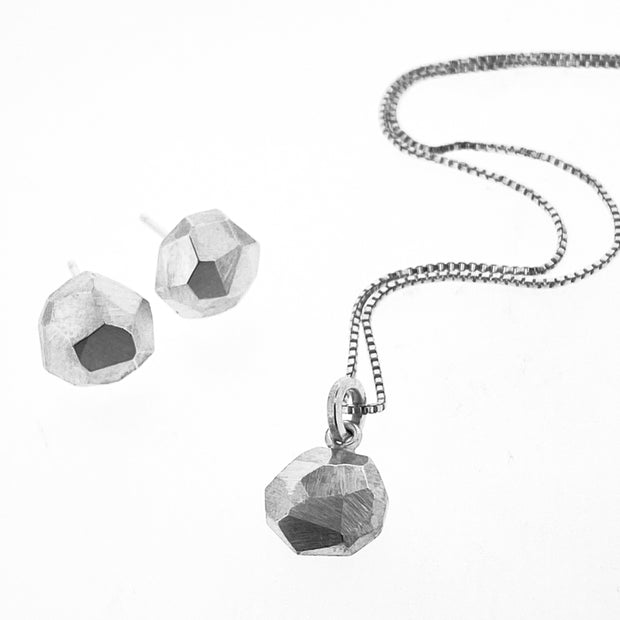 Full view of octagon pendant on necklace with its matching earrings next to it.
