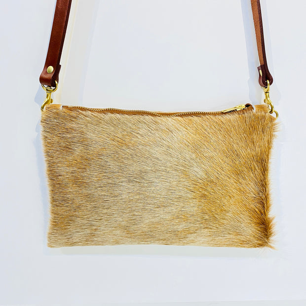 Full image of Wylie cross body bag in a blonde cowhide with brown leather straps.
