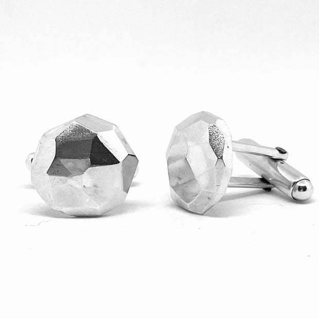Full view of faceted Cufflinks at an angle on a white background.