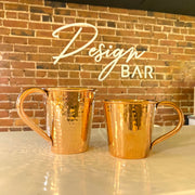 Full vie of small and large copper mule mugs standing next to each other to compare size.