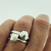 Full view of faceted small square and dome rings on finger to give idea of scale.