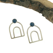 Full view of Melody Bow - Kyanite Earrings. These sterling earrings are made of wire and resemble the outline of a rainbow and at the tip of the rainbow is a set piece of circle kyanite.