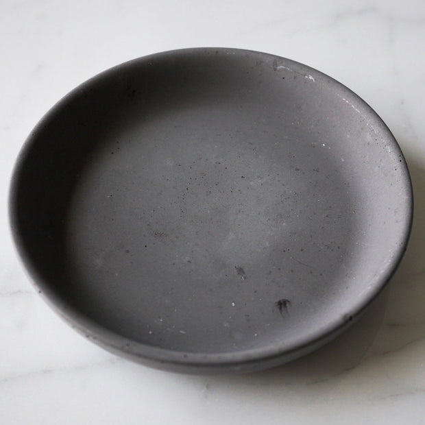 Angled view of circle concrete jewelry dish.