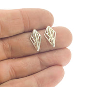 Full image of Mini Openwork Studs held in a hand. These studs resemble a shield created with architectural motifs through silver wire.
