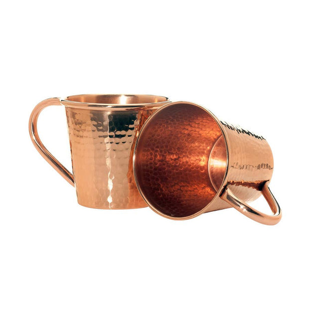 Full view of two large copper mule mugs, one laying down showcasing its inside and the other standing up.