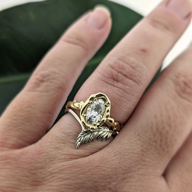 botanical leaf design nature inspired arched V shadow band wedding band, paired with moissanite long oval nature inspired twig style engagement ring