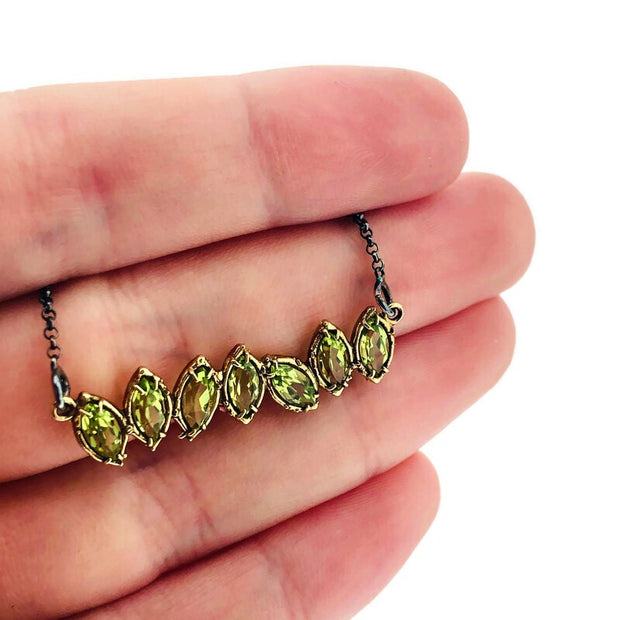 Detail shot of pendant on peridot Two Tone Cherin Necklace on woman's hand to help give an idea of its size.