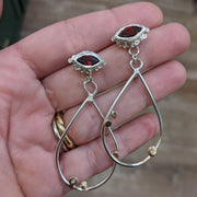 Full view of Trena Earring in-between two fingers to help give an idea of its scale.